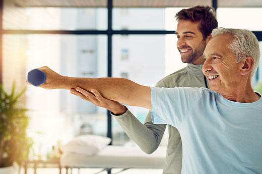 The right choice for patients and providers Male physical therapist aiding retired gentleman with rehabilitation exercise.