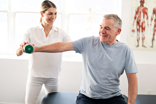 Our Services Woman assisting a man with a weighted arm exercise.